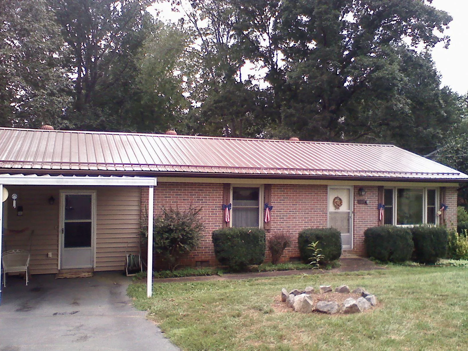 Bronze metal roof and carport on a brick ranch home — Roof Repair work by our crew in Pickens